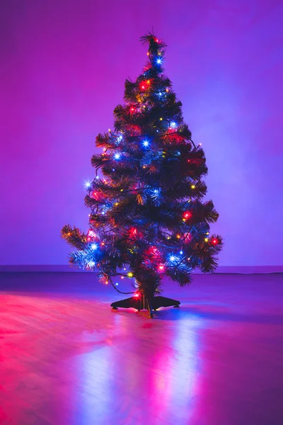Рождественская елка с фиолетовыми гирляндами — стоковое фото