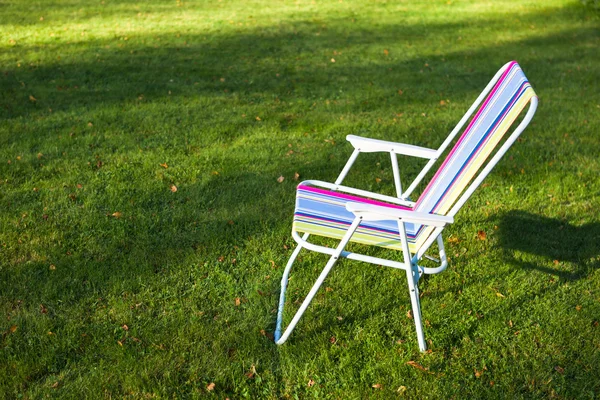 Καρέκλα κήπου σε φόντο πράσινο γρασίδι — Φωτογραφία Αρχείου