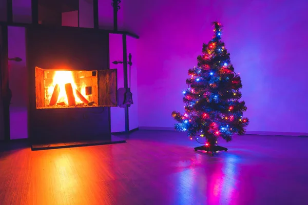 Kerstboom met lampjes garland en open haard — Stockfoto