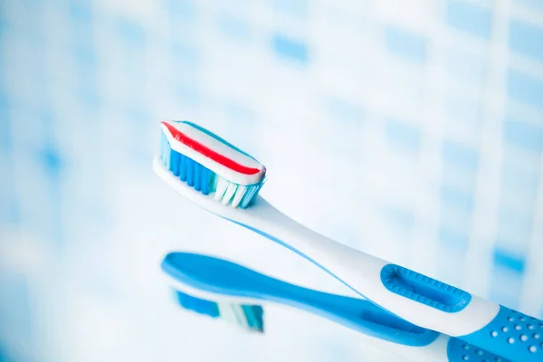 Blue toothbrush with red stripe toothpaste — Stock Photo, Image