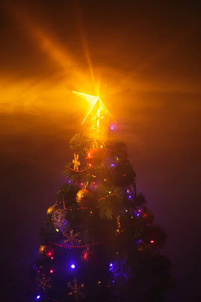 Kerstboom met stralende ster en dichte rook — Stockfoto