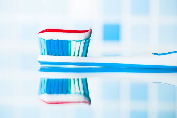 Toothbrush with red stripe toothpaste and mirror reflection — Stock Photo, Image