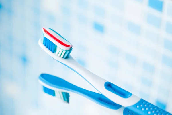 Escova de dentes com pasta de dentes listrada vermelha — Fotografia de Stock