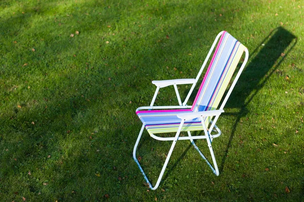Cadeira de jardim no fundo do gramado verde — Fotografia de Stock