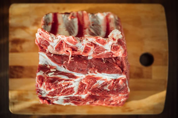 Piece of raw beef meat on wooden board, top view — Stock Photo, Image