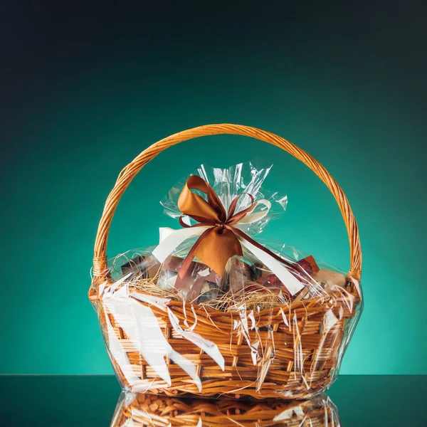 Gift basket on emerald background — Stock Photo, Image