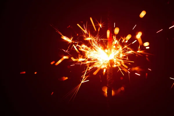 Christmas sparkler in haze with red light — Stock Photo, Image