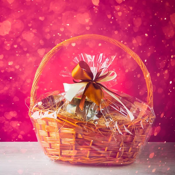 De mand van de gift met feestelijke hart deeltjes, paarse achtergrond — Stockfoto