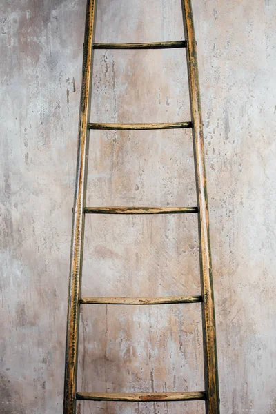 Idade idade escada de madeira no fundo da parede de concreto — Fotografia de Stock