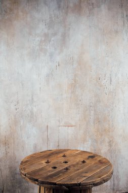 Beton duvar arka plan karşı eski ahşap makara parçası