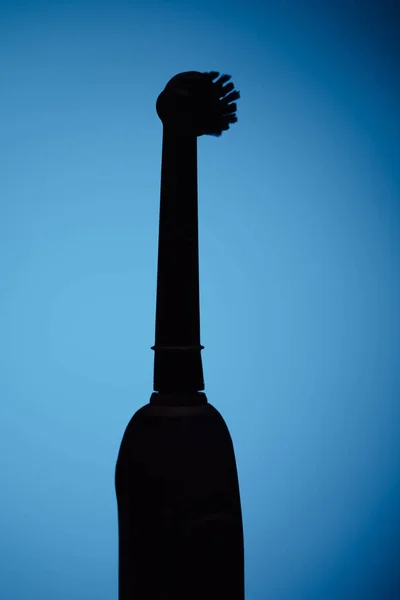 Elektrikli diş fırçası siluet, mavi arka plan — Stok fotoğraf