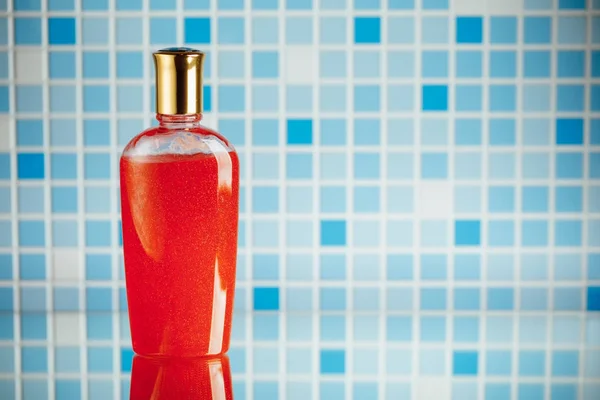Red shower gel on blue tile background — Stock Photo, Image