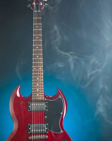 Guitarra elétrica em fumaça, fundo azul — Fotografia de Stock