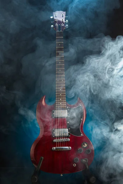 Electric guitar in smoke, blue background — Stock Photo, Image