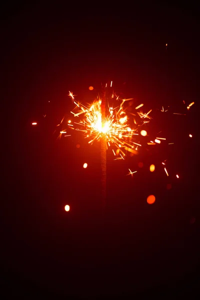 Christmas sparkler in haze with red light — Stock Photo, Image