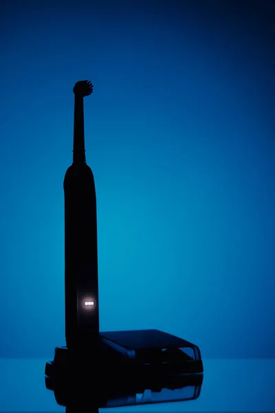 Ηλεκτρική οδοντόβουρτσα σιλουέτα, μπλε φόντο — Φωτογραφία Αρχείου