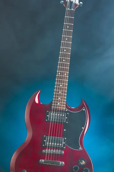 Guitarra eléctrica en humo, fondo azul — Foto de Stock