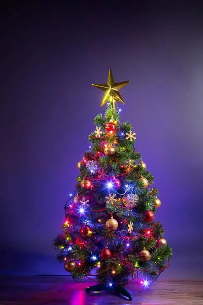 Árbol de Navidad con luces festivas, fondo púrpura —  Fotos de Stock