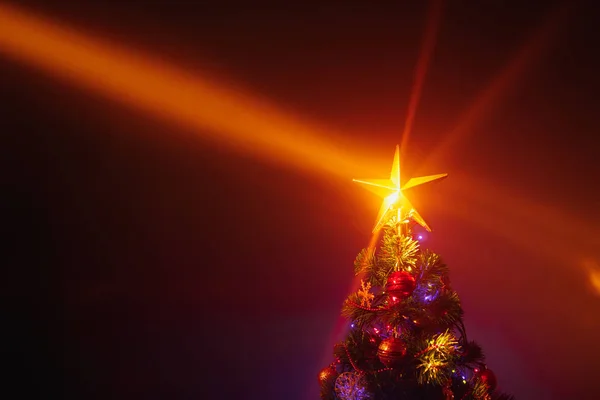 Weihnachtsbaum mit festlichen Lichtern, orangefarbener Hintergrund mit Nebel — Stockfoto