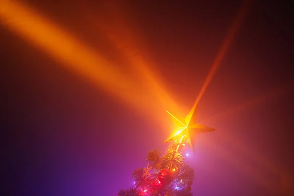 Kerstboom glanzende ster lichten, paarse achtergrond met mist — Stockfoto