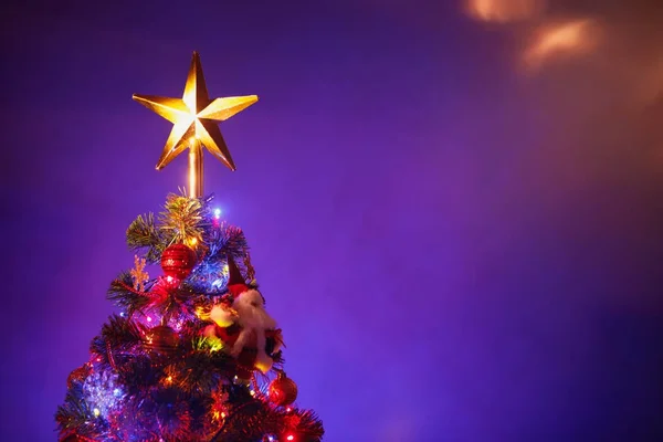 Árbol de Navidad con estrella festiva, fondo púrpura — Foto de Stock
