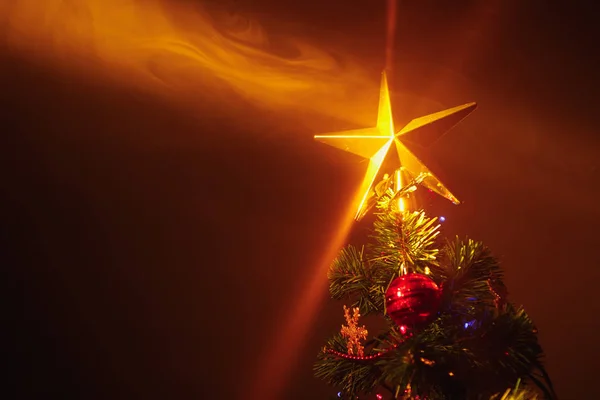 Árbol de Navidad con luces festivas, fondo naranja con humo — Foto de Stock