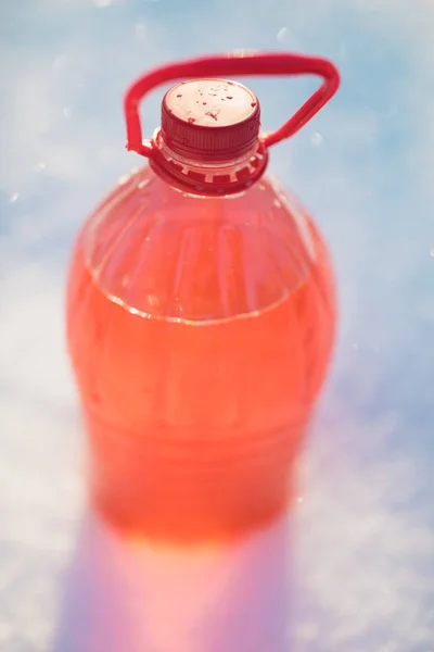 Láhev s nemrznoucí čelního skla ostřikovače, sníh pozadí — Stock fotografie
