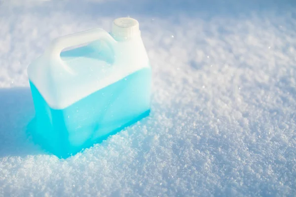 Bottiglia con liquido lavavetri antigelo, fondo neve — Foto Stock