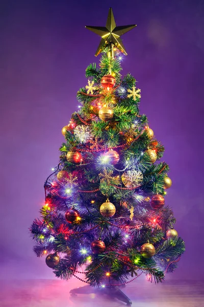 Weihnachtsbaum mit festlichen Lichtern, lila Hintergrund mit Rauch — Stockfoto