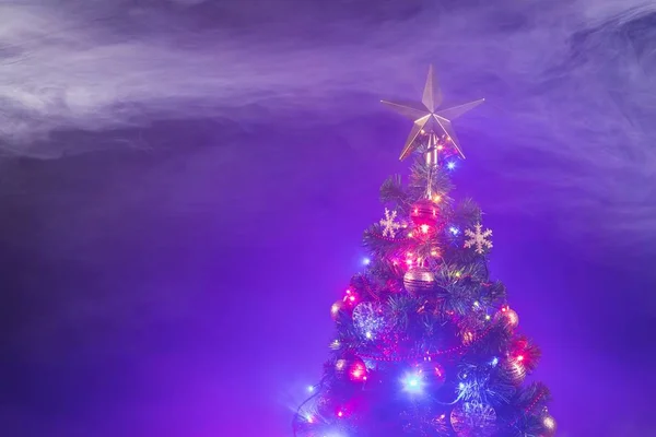 Arbre de Noël avec lumières festives, fond violet avec fumée — Photo