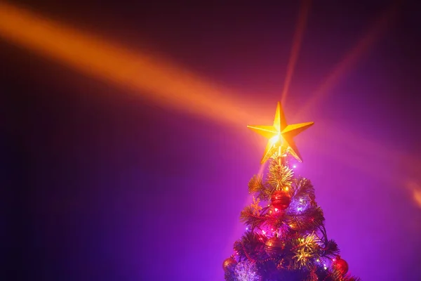 Albero di Natale con luci festive, sfondo viola — Foto Stock