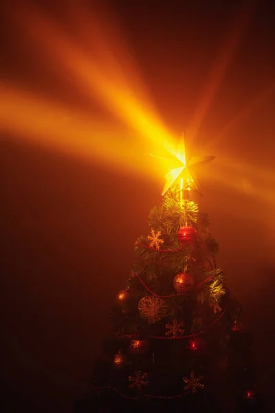 Weihnachtsbaum glänzende Sternenlichter, orangefarbener Hintergrund mit Nebel — Stockfoto