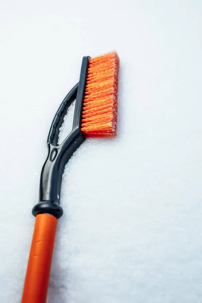 orange snow brush for car, snowflakes background