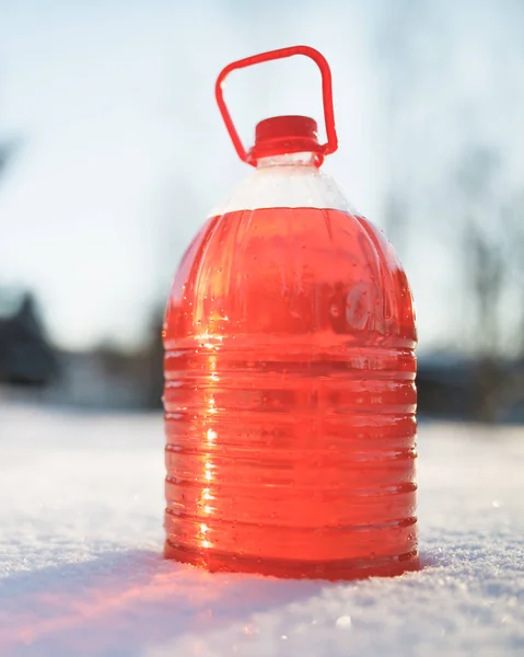 Butelka z niezamarzającej płyn do spryskiwaczy, śnieg tło — Zdjęcie stockowe