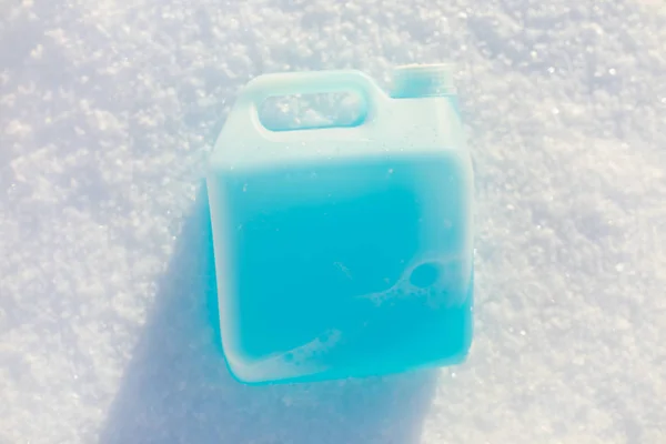 Bottle with non-freezing windshield washer fluid, snow background — Stock Photo, Image