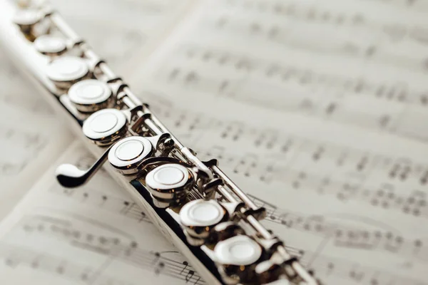 Flauta transversal en la hoja de música —  Fotos de Stock