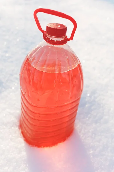 Bottle with non-freezing windshield washer fluid, snow background — Stock Photo, Image