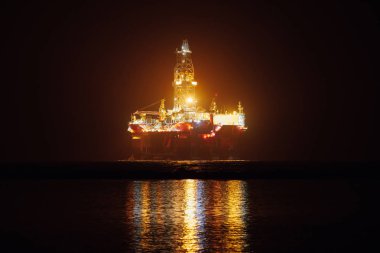 offshore oil platform at night clipart