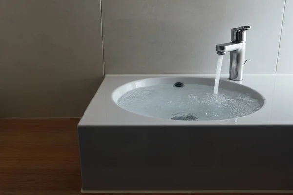 Wasserhahn mit fließendem Wasser im Waschbecken — Stockfoto