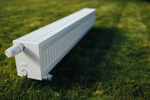 Radiador en césped verde, concepto de calefacción ecológica — Foto de Stock