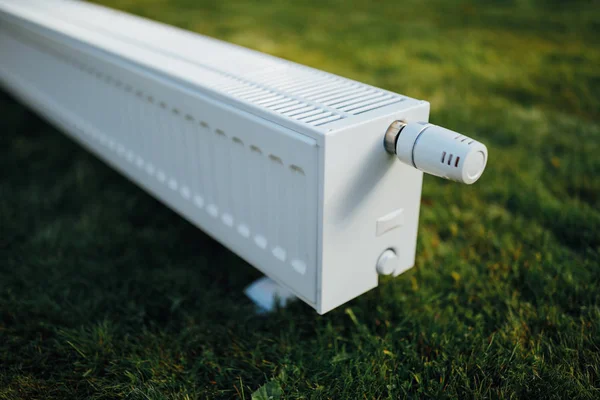 Radiator on green lawn, ecological heating concept — Stock Photo, Image