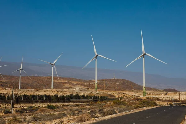Электрические ветряные турбины фермы, синий фон неба — стоковое фото