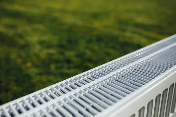 Radiator op groen gazon, ecologische verwarming concept — Stockfoto