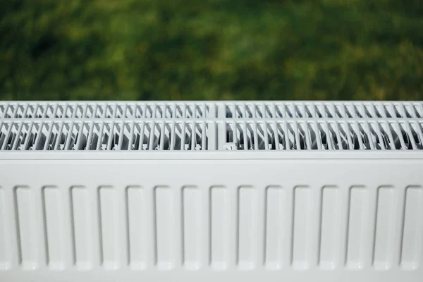 Radiador en césped verde, concepto de calefacción ecológica —  Fotos de Stock