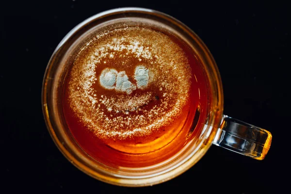 Teeform in einer Tasse, schwarzer Hintergrund — Stockfoto