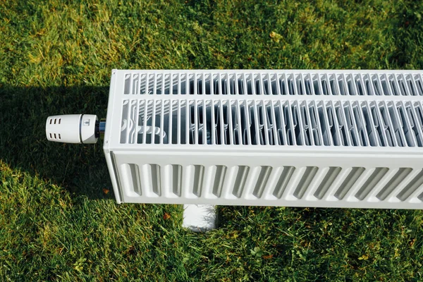 Radiateur sur pelouse verte, concept de chauffage écologique — Photo