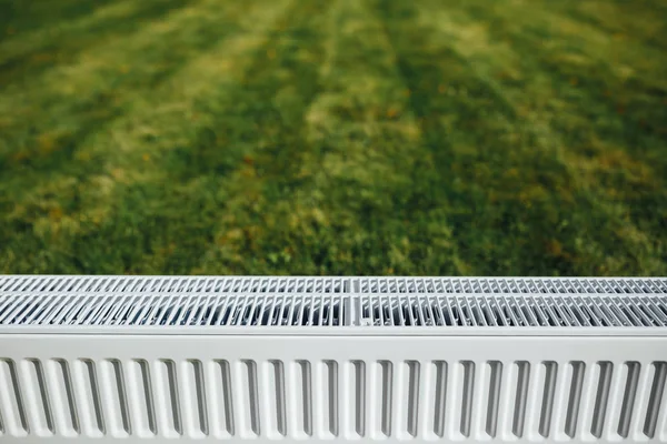 Radiador no gramado verde, conceito de aquecimento ecológico — Fotografia de Stock