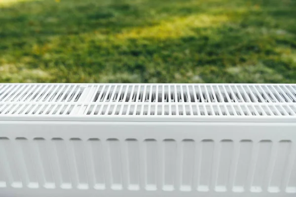 Radiateur sur pelouse verte, concept de chauffage écologique — Photo