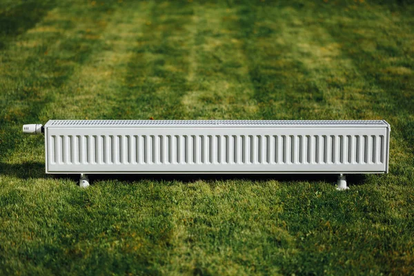 Radiator op groen gazon, ecologische verwarming concept — Stockfoto