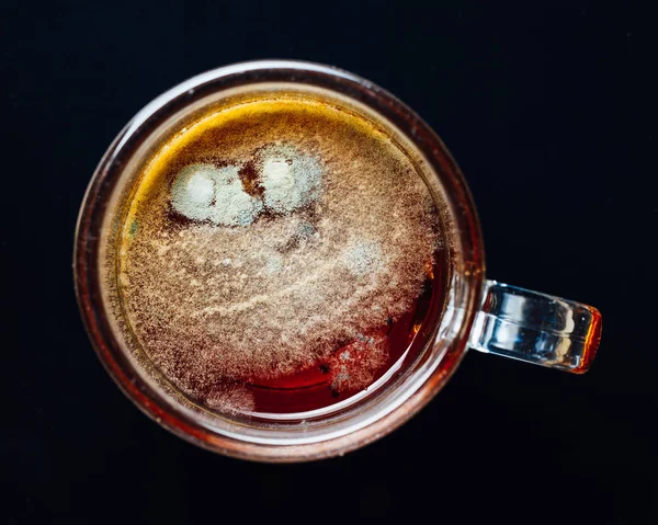Čaj plíseň v poháru, černé pozadí — Stock fotografie